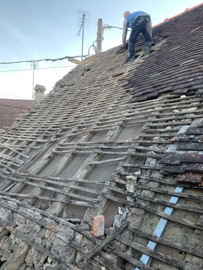 Dépose en cours des tuiles d'une toiture à rénover, par nos artisans couvreurs qualifiés